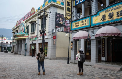 People walking on street against buildings in city