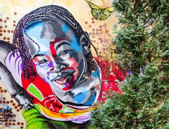 Portrait of man wearing multi colored graffiti on tree