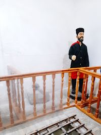 Man standing on staircase against wall