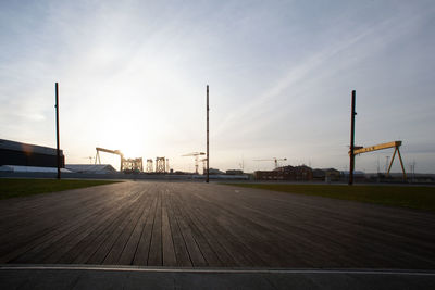 Empty road by airport runway against sky