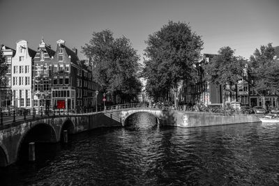 Bridge over river in city against sky