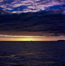 Scenic view of sea against dramatic sky during sunset