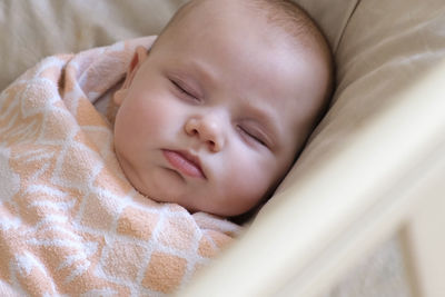 Safe sleep for baby, swaddle. adorable newborn sleeping swaddled in bed. swaddling for infants. 
