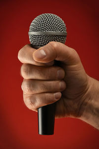 Close-up of hand holding hair over white background