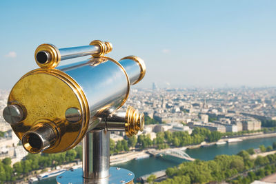 Close-up of coin-operated binoculars at eiffel tower against cityscape