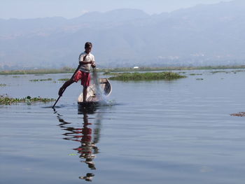 Full length of men in lake against sky