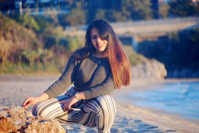Portrait of smiling young woman sitting outdoors