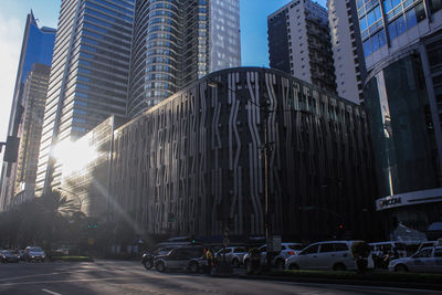 Cars on road by buildings in city