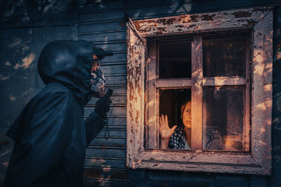 Fictional movie poster. people with flashlights, masks and protective clothing inspect old house. 