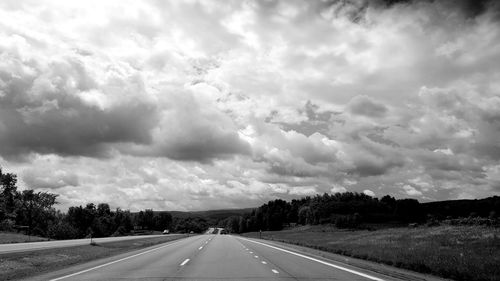 Empty road against cloudy sky