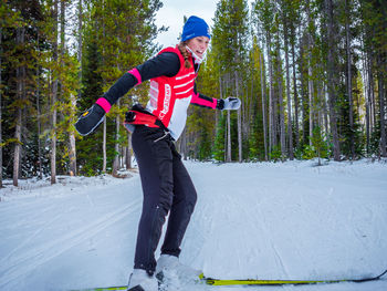 Woman standing on snow covered forest