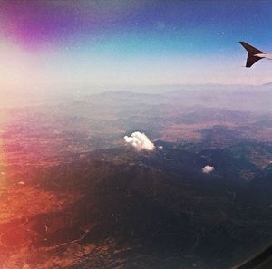 Cropped image of airplane flying over clouds