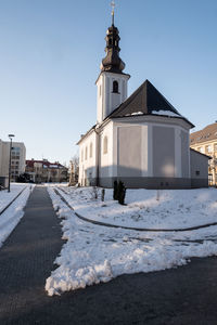 Snow covered buildings against clear sky