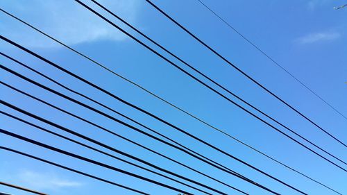 Low angle view of cables against blue sky