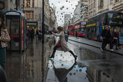 People walking on wet street during rainy season