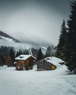 Houses on snow covered landscape against sky