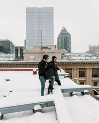 Full length of woman and buildings in city during winter