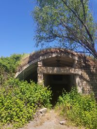 Low angle view of abandoned building against clear blue sky