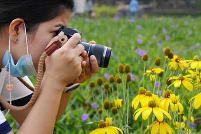 Midsection of woman photographing at camera