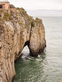 Rock formation in sea against sky