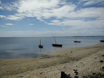 Sailboats in sea against sky