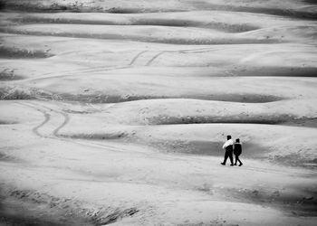 People walking on snow covered landscape