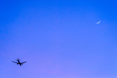 Low angle view of airplane flying against clear sky