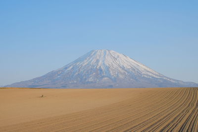 Scenic view of desert against clear blue sky