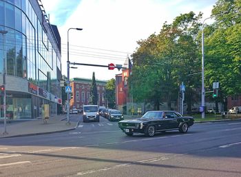 Cars on city street against sky