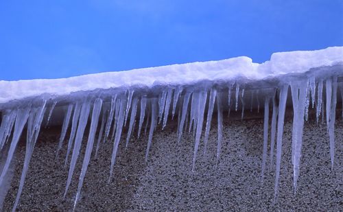 Close-up of frozen water against sky