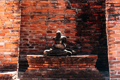 Statue against brick wall