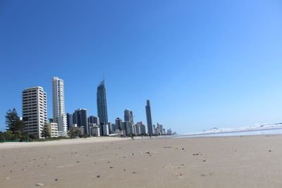 View of beach and buildings against blue sky