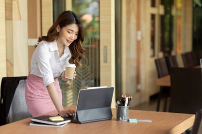 Young woman drinking coffee cup on table