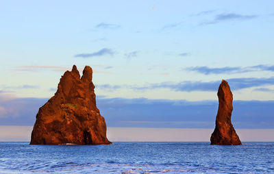 Rock formation in sea against sky