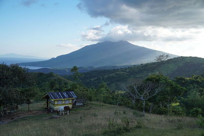 Scenic view of field and mountains against sky