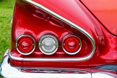 Tail lights and a wing on old red american car