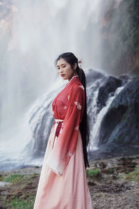 Side view of young woman standing on land