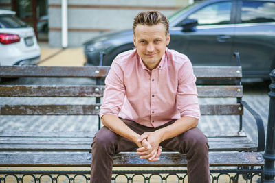 Portrait of young man sitting on bench