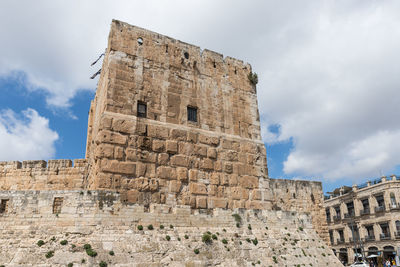 Low angle view of old building against cloudy sky