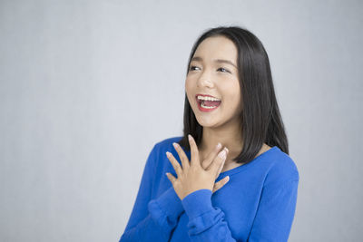 Portrait of a smiling young woman against white background