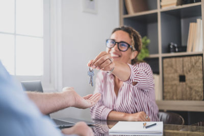 Young woman using phone while sitting at home