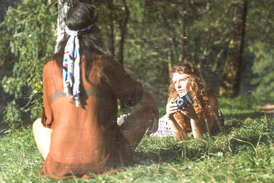 Rear view of woman sitting on land