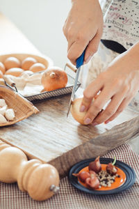 Cropped image of woman cutting onion in kitchen