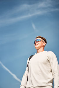 Man wearing sunglasses standing against sky