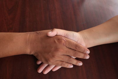 Close-up of couple hands on table