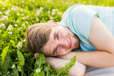 Portrait of smiling young woman lying on plant