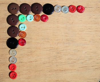 Directly above shot of colorful buttons arranged on wooden table