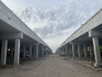 Empty road amidst buildings against sky