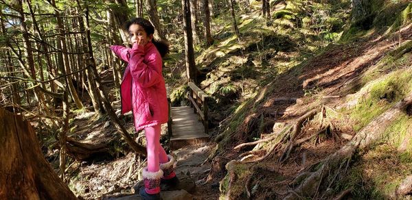 Portrait of cute girl standing in forest