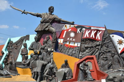 Low angle view of statues against sky